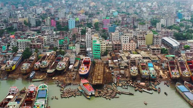Dhaka, Bangladesh - 23 August 2025: Aerial view of numerous boats docked near buildings, creating a vibrant contrast of maritime and urban landscapes.