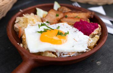 Scrambled eggs with fried bacon and potatoes served on plate