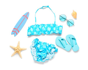 Children's swimsuit with beach accessories on white background