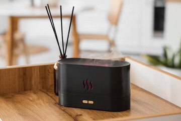 Air humidifier with reed diffuser on shelf in kitchen, closeup