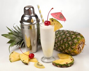 pina colada with typical fruits on white background