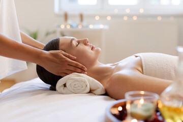Masseuse making relaxing head massage for young lady, woman getting healing head massage at spa in romantic atmosphere, side view