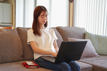 リビングでパソコンを操作する女性