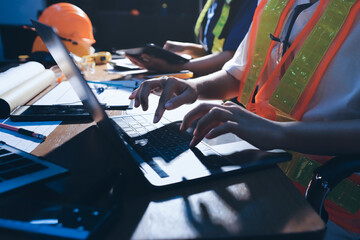 Closeup of team of industrial engineers meeting analyze machinery blueprints consult project on...