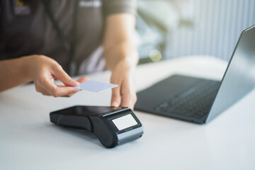 And Employee officer check verify identity ID card credit card business commercial cashier woman use card swipe machine pay for goods electronic