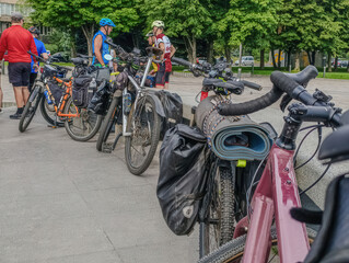 Group of cyclists resting outdoors leaving their bikes parked. Loaded touring bikes and cyclists...