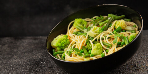 Spaghetti vegetables green peas, broccoli, string beans, kohlrabi vegetarian pasta tasty snack fresh delicious gourmet food background on the table rustic top view copy space vegan food