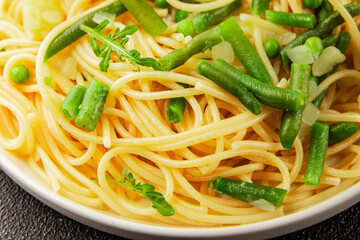 Spaghetti vegetables green peas, broccoli, string beans, kohlrabi vegetarian pasta tasty snack fresh delicious gourmet food background on the table rustic top view copy space vegan food