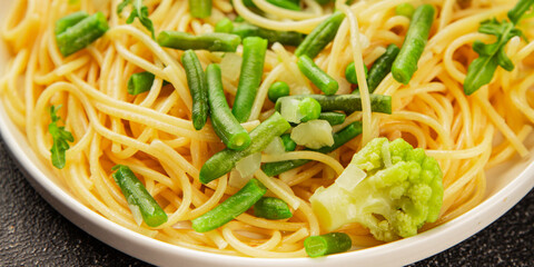 Spaghetti vegetables green peas, broccoli, string beans, kohlrabi vegetarian pasta tasty snack fresh delicious gourmet food background on the table rustic top view copy space vegan food