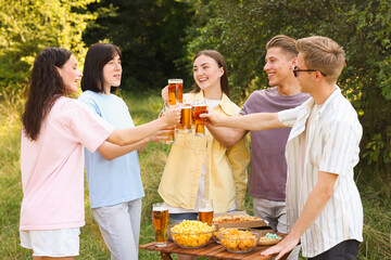 Group of happy friends clinking glasses of beer outdoors