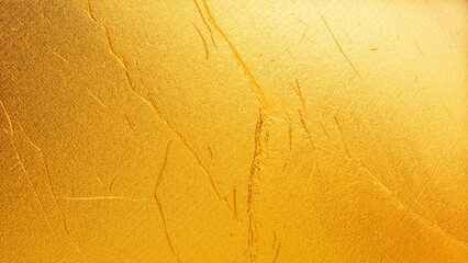 Golden plaster wall texture with subtle cracks and rough surface, elegant abstract background for...