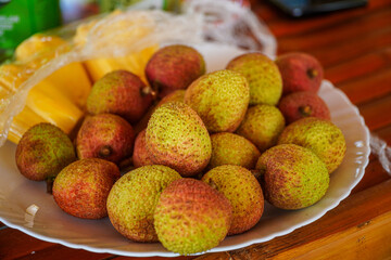 A vibrant platter of freshly picked lychees, their textured skin hinting at the sweet, juicy...