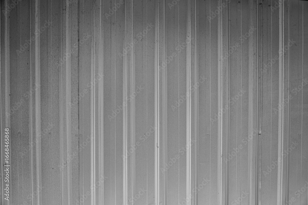 Poster a monochromatic gray metal wall showcases a series of vertical stripes. the industrial background is