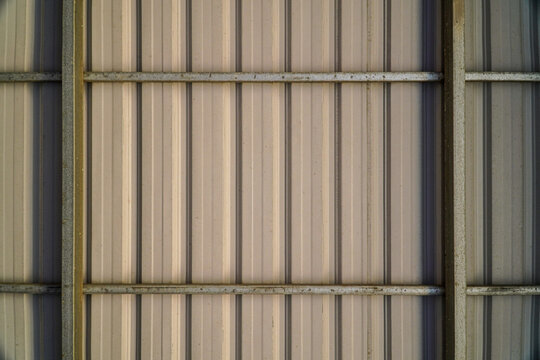 Abstract metal texture with a ribbed pattern, showcasing architectural structure and industrial design. Neutral tones and metallic surfaces create a versatile backdrop for various concepts.