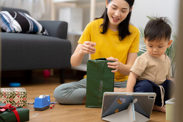 An Asian mother and son do activities together at home, such as dressing up, playing games, playing ball, and drawing.