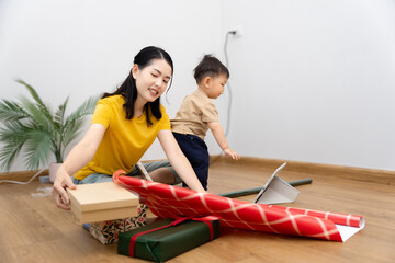 An Asian mother and son do activities together at home, such as dressing up, playing games, playing ball, and drawing.