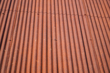A close-up view showcases a patterned corrugated surface, rich with textures and linear design. The interplay of light and shadow enhances its dimensional quality, rustic aesthetic.