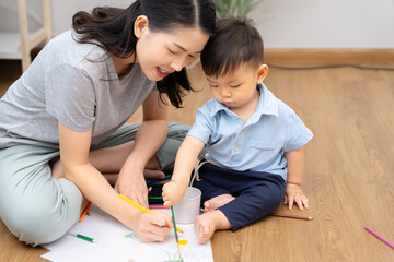 An Asian mother and son do activities together at home, such as dressing up, playing games, playing ball, and drawing.