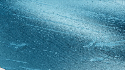 Abstract close-up of metallic blue foil texture with reflective details and smooth gradient tones,...