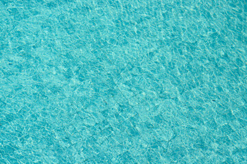 Vibrant blue water surface with shimmering reflections and ripples under sunlight