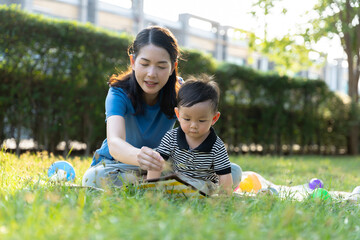 Asian mother and son doing activities together in the grass