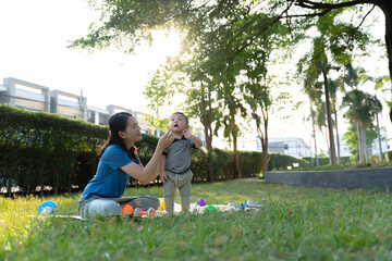 Asian mother and son doing activities together in the grass