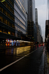 Fototapeta premium NYC New York City - Wet Streets Reflecting Skyscrapers in Financial District at Dusk