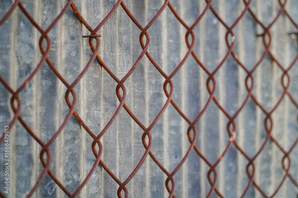 Poster a close-up perspective of a rusted wire fence against a textured background presents industrial text