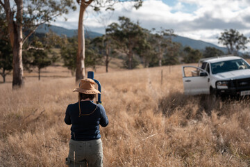 female farmer fencing on a farm reeling a electric fence a farm putting up a steel post fence with...