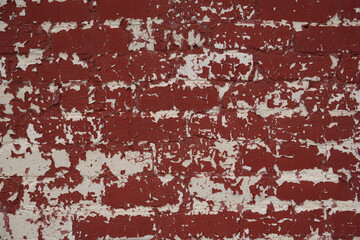 Red brick wall with cracked paint