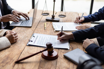 Lawyers and clients signing contract agreement after legal advice consultation. Lawyers and clients are signing contract agreements on a wooden table, legal proceedings and agreement.
