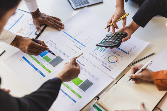 Business people consultant analyzing financial charts and report in a meeting. Business team analyzing financial reports using calculator to discuss investment strategy.