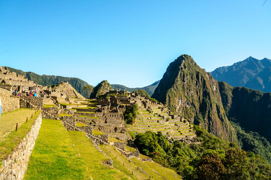 Panoramablick auf die majest&auml;tischen Ruinen von Machu Picchu und den dahinterliegenden Huayna Picchu, unter einem klaren blauen Himmel