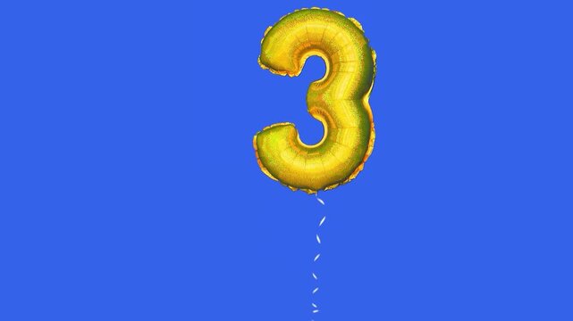 foil balloon with number 3 moving across blue screen