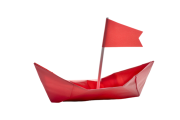 Red paper boat with flag sailing on black background
