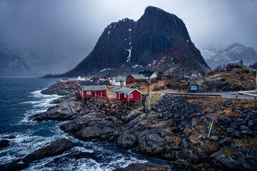 Scenic view of red cabins on rocky coast.