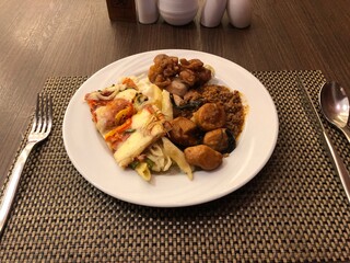 Plate of assorted buffet food on a table setting at a restaurant