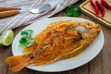 Deep fried red tilapia fish on white plate