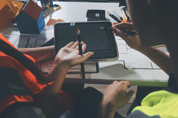 Closeup of team of industrial engineers meeting analyze machinery blueprints consult project on...