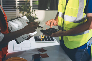 Closeup of team of industrial engineers meeting analyze machinery blueprints consult project on...