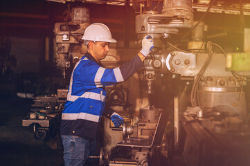 A male mechanical engineer is inspecting work in a steel lathe factory.