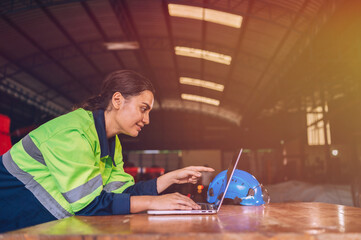 A female mechanical engineer is inspecting work in a steel lathe factory.