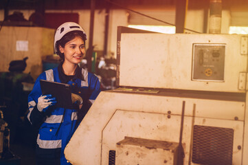 A female mechanical engineer is inspecting work in a steel lathe factory.