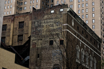 NYC New York City - Bowery Savings Bank Sign on Weathered Brick Wall Contrasts Modern Cityscape