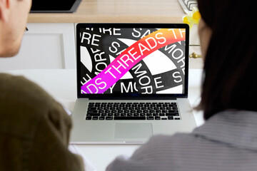 Colleagues discussing more threads and ads strategy on laptop