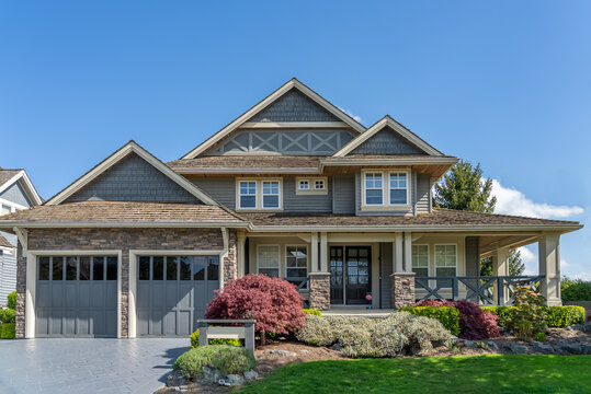 Two story stucco luxury house with nice spring blossom landscape in Vancouver, Canada, North America. Day time on May 2025. - Powered by Adobe