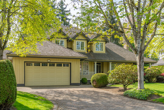 Two story stucco luxury house with nice spring blossom landscape in Vancouver, Canada, North America. Day time on May 2025.