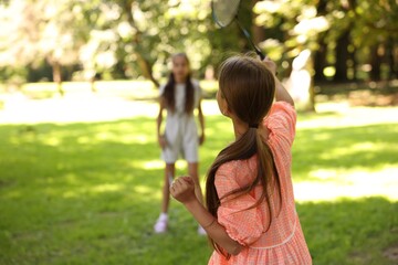Cute little girls playing badminton in park, selective focus