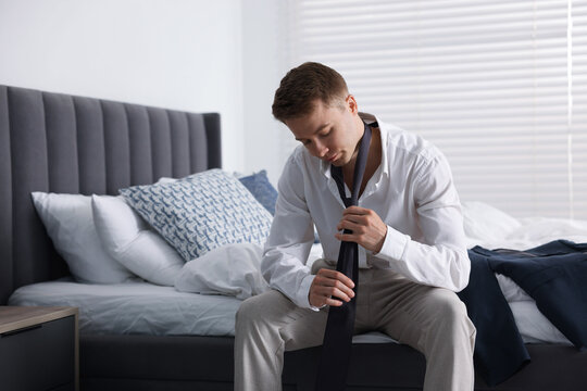 Sad young man getting ready at home