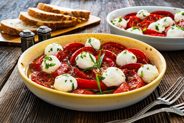 Roasted tomatoes and labneh cheese salad on wooden table